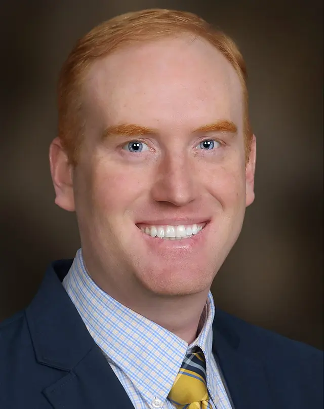 Dr. Jedidiah Oldham in white coat welcoming patients at the care team clinic